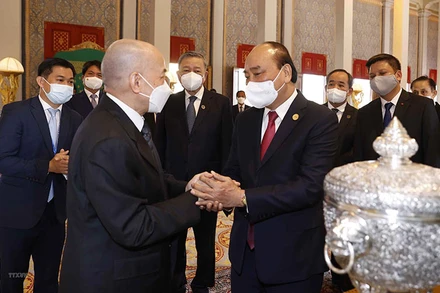 Chủ tịch nước Nguyễn Xuân Phúc và Quốc vương Campuchia Norodom Sihamoni giới thiệu về của quà tặng của hai nước tại Cung điện Hoàng gia. (Ảnh: TTXVN)