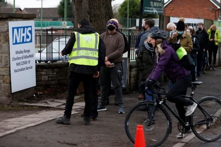 Xếp hàng chờ tiêm vaccine phòng Covid-19 liều tăng cường bên ngoài 1 trung tâm tiêm chủng ở Manchester, Anh, ngày 13/12/2021. (Ảnh: Reuters)