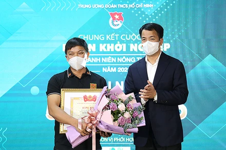 Tác giả dự án “Nông trại Cờ Đỏ”, anh Lương Văn Trường (bên trái trong ảnh) nhận giải nhất Cuộc thi “Dự án khỏi nghiệp thanh niên nông thôn” năm 2021.