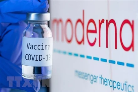 Vaccine ngừa Covid-19 bên biểu tượng của hãng dược phẩm Moderna. (Ảnh: AFP/TTXVN)