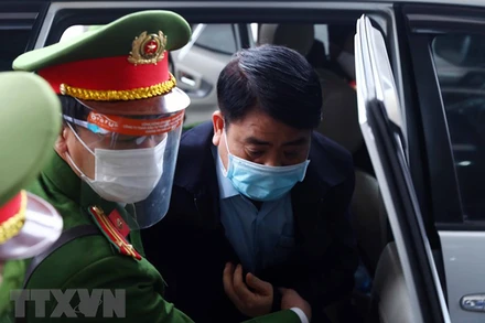 Bị cáo Nguyễn Đức Chung (cựu Chủ tịch Ủy ban Nhân dân thành phố Hà Nội) được lực lượng chức năng dẫn giải đến phiên tòa. (Ảnh: TTXVN)