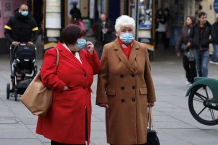 Người dân đeo khẩu trang chờ sang đường ở London, Anh, ngày 21/12/2021. (Ảnh: Reuters)