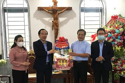 Đồng chí Ngô Sách Thực (thứ 2 từ trái qua) tặng quà, chúc mừng Giáng sinh tại Giáo xứ Tam Tòa.