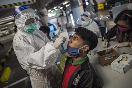 Nhân viên y tế lấy mẫu xét nghiệm Covid-19 cho người dân tại Surabaya, Indonesia ngày 17/6/2021. (Ảnh: AFP/TTXVN).