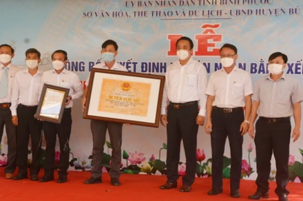 Lãnh đạo Sở Văn hóa, Thể thao và Du lịch tỉnh Bình Phước trao bằng xếp hạng Di tích lịch sử quốc gia địa điểm thảm sát ở Bù Đốp (16/3/1978) cho đại diện địa phương.