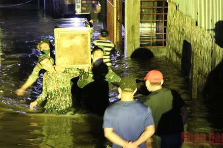 Cán bộ chiến sĩ Bộ chỉ huy Quân sự tỉnh Phú Yên giúp người dân có nhà bị triều cường gây ngập đến nơi an toàn.