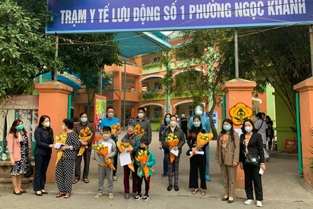 Phó Chủ tịch UBND quận Ba Đình Phạm Thị Diễm tặng hoa, chúc mừng và động viên các trường hợp khỏi bệnh. (Ảnh: Mai Hữu)