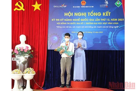 Phó Chủ tịch Ủy ban nhân dân tỉnh Vĩnh Long Nguyễn Thị Quyên Thanh trao Huy chương vàng cho thí sinh Trường đại học Sư phạm Kỹ thuật Vĩnh Long vào chiều 12/12. (Ảnh: BÁ DŨNG) 