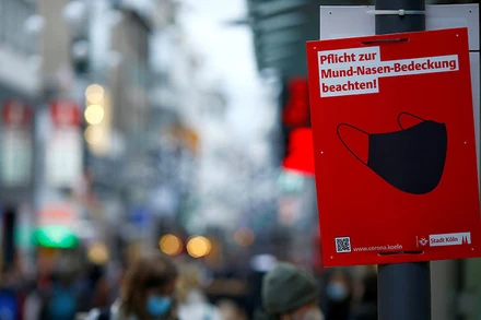 Biển nhắc nhở người dân che miệng và mũi trên phố mua sắm Strasse tại TPCologne, Đức, tháng 12/2021. (Ảnh: Reuters)