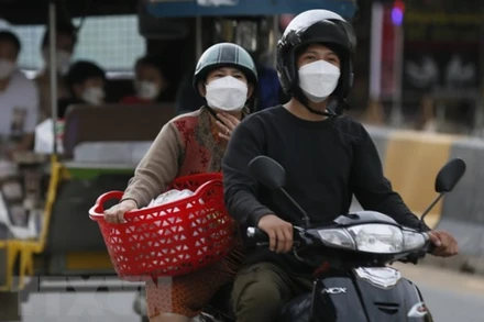 Người dân đeo khẩu trang khi tham gia giao thông ở Campuchia. (Ảnh: THX/TTXVN)
