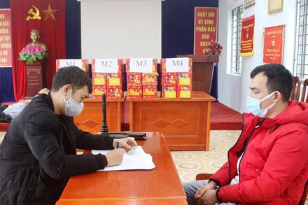 Đối tượng Phạm Văn Tiệp (áo đỏ) và tang vật tại cơ quan công an.