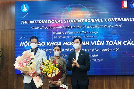 Đồng chí Nguyễn Minh Triết (bên phải trong ảnh) trao hoa tặng các đại biểu trí thức trẻ tham gia Hội thảo tại đầu cầu thành phố Hà Nội.