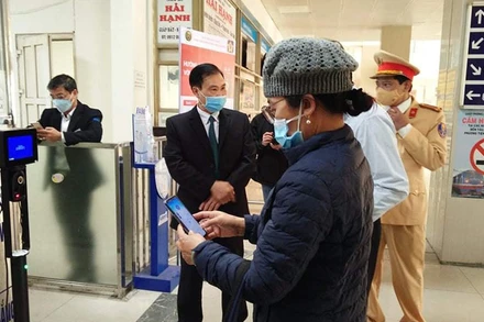 Lực lượng Cảnh sát giao thông Hà Nội hướng dẫn người dân thao tác quét mã QR để khai báo y tế ở bến xe.