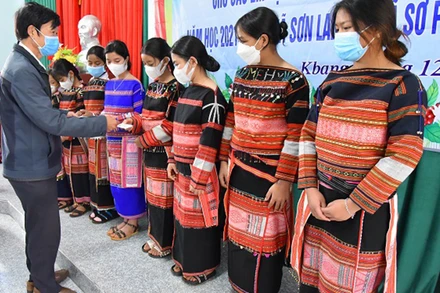 Tặng thẻ bảo hiểm y tế cho học sinh người dân tộc thiểu số có hoàn cảnh khó khăn. (Ảnh: Bảo hiểm xã hội Gia Lai)