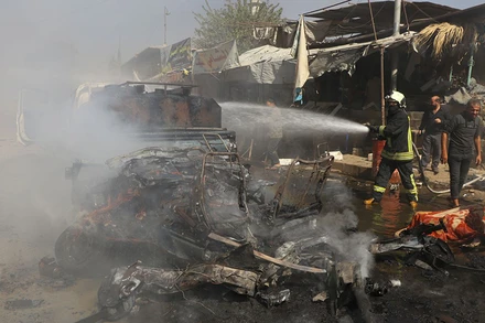 Nhân viên cứu hỏa dập đám cháy trên xe ô-tô tại Afrin, Syria, ngày 11/10/2021. (Ảnh: Reuters)