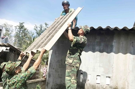 Bộ đội giúp người dân sửa chữa những ngôi nhà bị tốc mái. Ảnh: Báo Quân đội nhân dân
