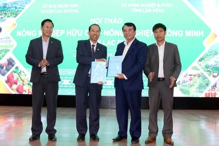 Tiến sĩ Phạm S (thứ hai, bên phải) trao “Quy trình độc quyền canh tác cà-phê arabica hữu cơ vùng núi Langbiang” tặng huyện Lạc Dương.
