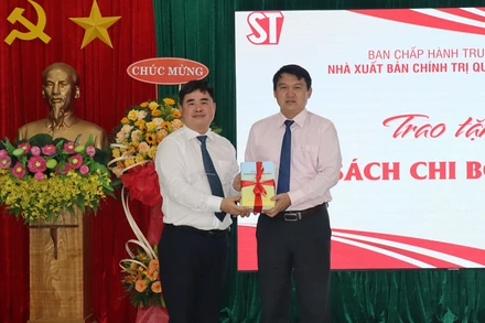 Giám đốc, Tổng Biên tập Nhà xuất bản Chính trị quốc gia Sự thật PGS, TS Phạm Minh Tuấn (bên trái) tặng sách tới Thành ủy Cam Ranh. (Ảnh: PHONG NGUYÊN)