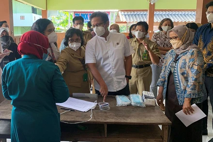 Bộ trưởng Y tế Indonesia Budi Gunadi Sadikin trò chuyện với nhân viên y tế bên lề một sự kiện của G20 diễn ra tại nước này, ngày 29/3. (Ảnh: Reuters)