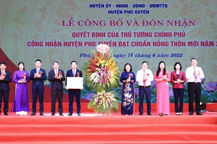 Lãnh đạo huyện Phú Xuyên đón nhận Quyết định của Thủ tướng Chính phủ công nhận huyện đạt chuẩn nông thôn mới năm 2020. (Ảnh: Ngọc Anh)