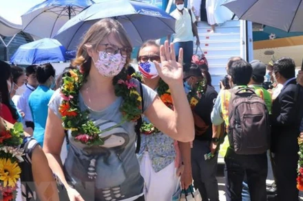 Tặng hoa chào đón du khách đến Khánh Hòa. (Ảnh: TTXVN)