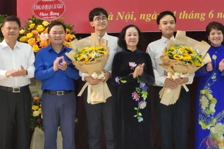 Đồng chí Trương Thị Mai tặng hoa hai đảng viên trẻ tại Trường THPT chuyên Hà Nội-Amsterdam. (Ảnh: SƠN BÁCH)