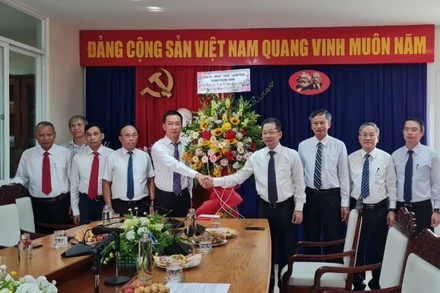 Đồng chí Nguyễn Văn Quảng tặng hoa chúc mừng cán bộ phóng viên Cơ quan Thường trực Báo Nhân Dân tại Đà Nẵng.