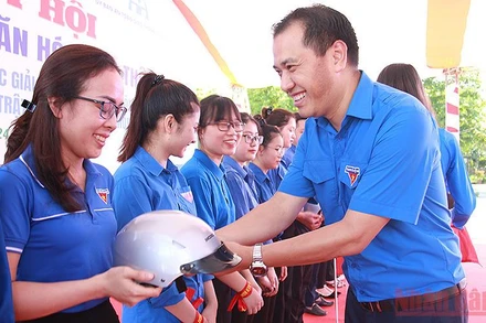 Phó Chủ tịch Thường trực Hội Liên hiệp Thanh niên Việt Nam Nguyễn Hải Minh (bên phải) trao mũ bảo hiểm tặng đoàn viên, thanh niên tham gia Ngày hội “Thanh niên với văn hóa giao thông”.