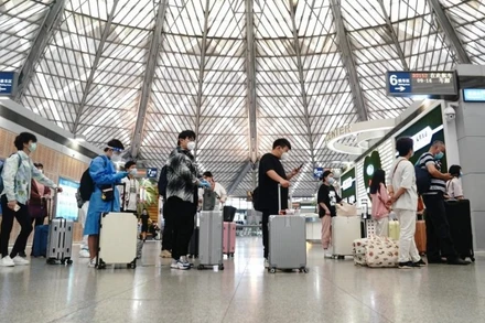 Hành khách xếp hàng lên chuyến tàu D2152 ở ga Nam Thượng Hải trong ngày đầu mở cửa trở lại. (Ảnh: Tân Hoa Xã)