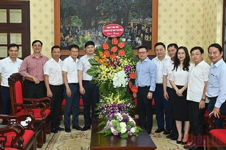 Tổng Biên tập Lê Quốc Minh cùng lãnh đạo Báo Nhân Dân đón nhận lẵng hoa chúc mừng của đoàn đại biểu Thành ủy, HĐND, UBND, Ủy ban MTTQ Việt Nam TP Hải Phòng. (Ảnh: DUY LINH)