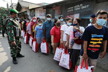 Người dân đeo khẩu trang trong lúc xếp hàng nhận hỗ trợ tain thủ đô Jakarta, ngày 16/7/2021. (Ảnh: Reuters)