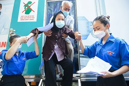 Đoàn viên, thanh niên tình nguyện hỗ trợ người dân khám bệnh tại chương trình. (Ảnh: Viết Niệm)