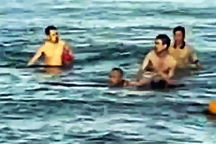 Hình ảnh Trung tá quân nhân chuyên nghiệp Bùi Văn Nhiên cùng người dân cứu cháu bé bị đuối nước. (ẢNH: QĐND)