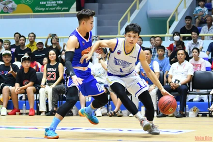 Chí Anh (áo trắng bên phía Hochiminh City Wings) dẫn bóng trước sự truy cản của Quang Anh. (Ảnh: THỦY NGUYÊN) 