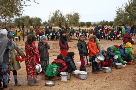 Người dân xếp hàng chờ được phát lương thực cứu trợ tại trại tị nạn ở Yazi Bagh, Aleppo, Syria. (Ảnh: AFP/TTXVN)