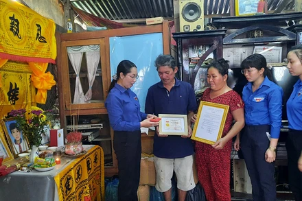 Quyền Bí thư Tỉnh đoàn Vĩnh Long Nguyễn Thụy Yến Phương trao Huy hiệu “Tuổi trẻ dũng cảm” cho gia đình em Nguyễn Minh Quân.