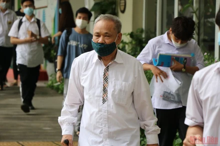 Ở tuổi 82, ông Kỳ vẫn… chống nạng, mặc áo sơ mi trắng và mang theo giấy bút đến trường thi để thực hiện… giấc mơ của mình. (Ảnh: Sơn Bách)