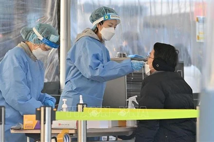 Nhân viên y tế lấy mẫu xét nghiệm Covid-19 cho người dân tại Seoul, Hàn Quốc. (Ảnh: AFP/TTXVN)
