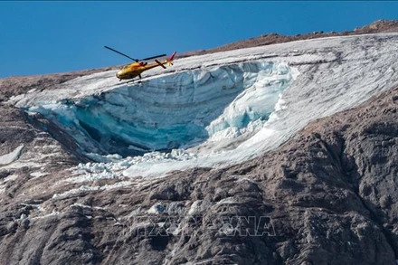 Trực thăng cứu hộ tìm kiếm nạn nhân tại hiện trường vụ lở tuyết trên núi Marmolada thuộc dãy Alps, Italia, ngày 4/7/2022. (Ảnh: AFP/TTXVN)