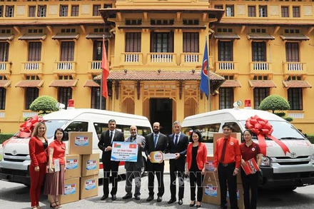 Các đại biểu trao tượng trưng xe cứu thương và vật tư y tế do Vương quốc Hồi giáo Oman tặng Hội Chữ thập đỏ Việt Nam. (Ảnh: TTXVN)