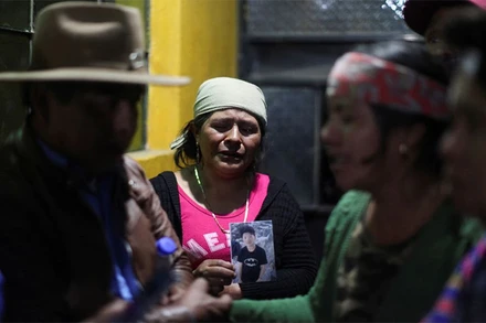 Mẹ của nạn nhân 13 tuổi trong vụ việc này cầm di ảnh của con trai. (Ảnh: Reuters)