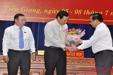 Đồng chí Võ Văn Bình, Phó Bí thư Thường trực Tỉnh ủy, Chủ tịch Hội đồng nhân dân tỉnh Tiền Giang tặng hoa chúc mừng đồng chí Nguyễn Hữu Lợi.