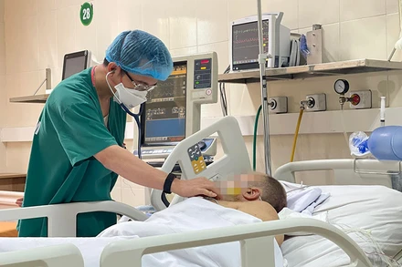 TS, BS Phạm Tiến Quân, Trưởng Khoa Hồi sức tích cực tim mạch và lồng ngực thăm khám cho bệnh nhân sau phẫu thuật.