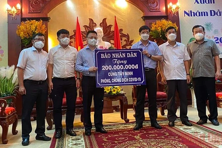 Đồng chí Lê Quốc Minh (trái) trao biển tượng trưng kinh phí chống dịch cho đồng chí Nguyễn Thành Tâm.