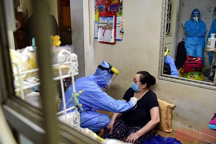 Nhân viên y tế khám sàng lọc trước tiêm chủng cho người dân tại nhà. (Ảnh: THÀNH ĐẠT)