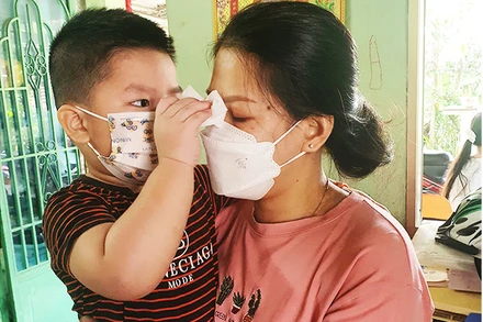 Em bé đang lau nước mắt cho mẹ. Sau mất mát, các con nhận về nhiều sự quan tâm, hỗ trợ từ cộng đồng.