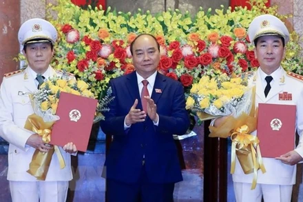 Chủ tịch nước Nguyễn Xuân Phúc trao Quyết định thăng cấp bậc hàm từ Trung tướng lên Thượng tướng đối với Thứ trưởng Công an Trần Quốc Tỏ và Lương Tam Quang. (Ảnh: Thống Nhất/TTXVN)