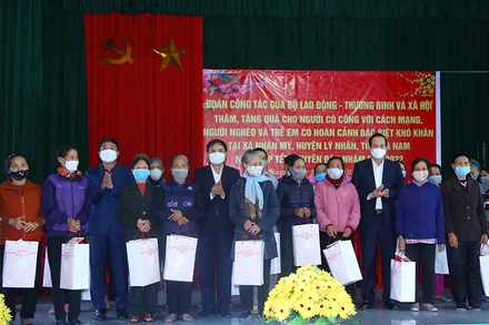 Bộ trưởng Đào Ngọc Dung, lãnh đạo tỉnh Hà Nam tặng quà gia đình chính sách, hộ nghèo tại chương trình. (Ảnh: Molisa)