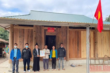 Lãnh đạo xã Pú Hồng, huyện Điện Biên Đông trao nhà, ảnh Bác Hồ cho hộ nghèo ở bản Phiêng Muông, xã Pú Hồng.