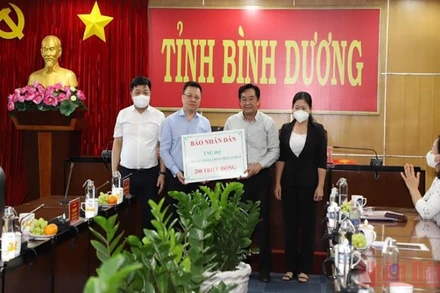 Tổng Biên tập Báo Nhân Dân Lê Quốc Minh trao 200 triệu đồng của Báo Nhân Dân ủng hộ tỉnh Bình Dương phòng, chống dịch bệnh Covid-19.